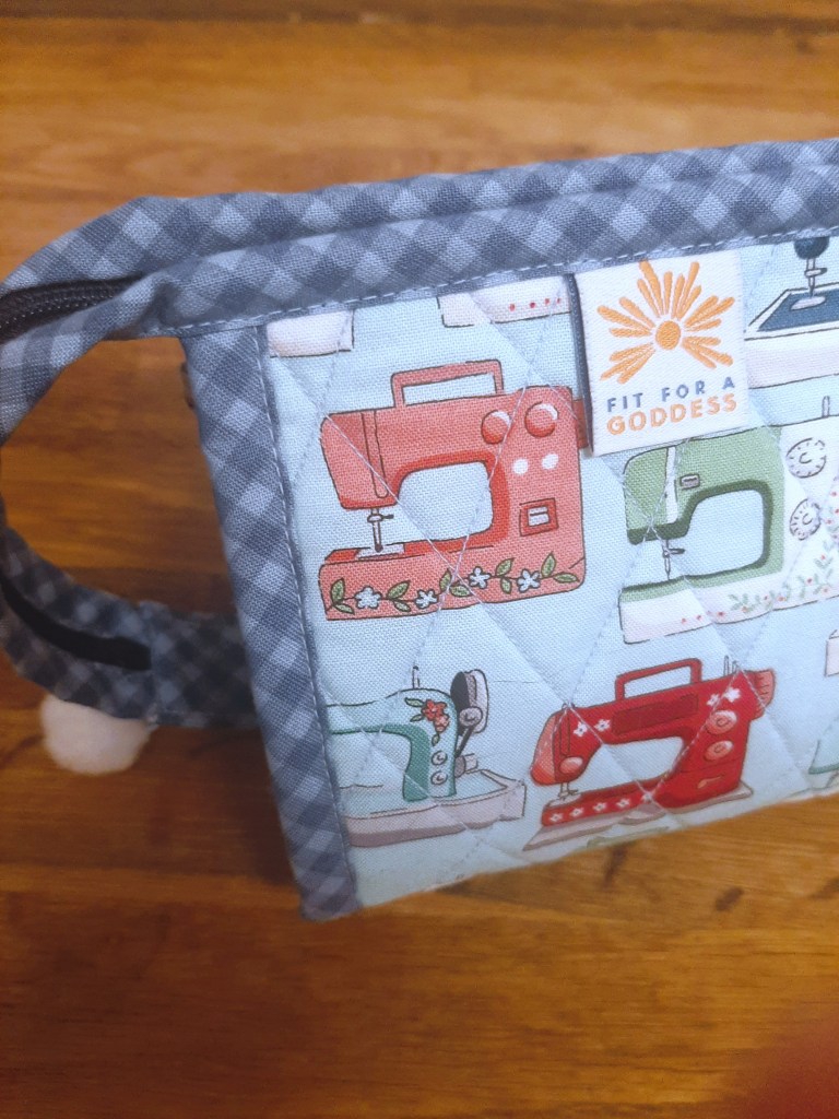 Close-up of handmade quilted zipper pouch using blue fabrics with a sewing machine for the main pattern